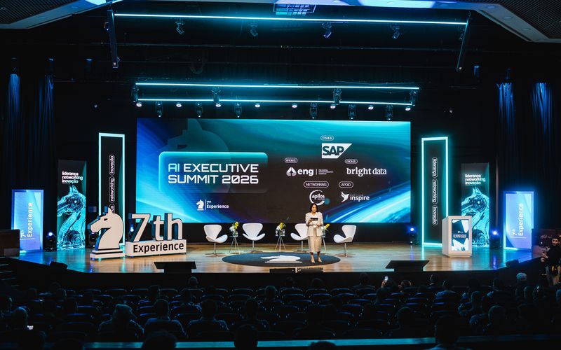 Palco do AI Executive Summit do 7Th AI Experience com telas de LED e conteúdo digital