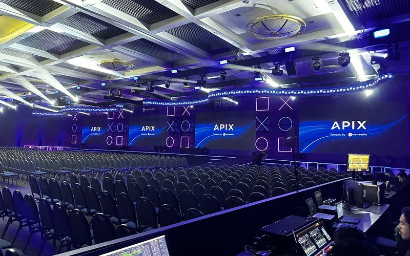 Plenária do APIX 2026 montada com painéis de LED, iluminação cênica e estrutura pronta para operação